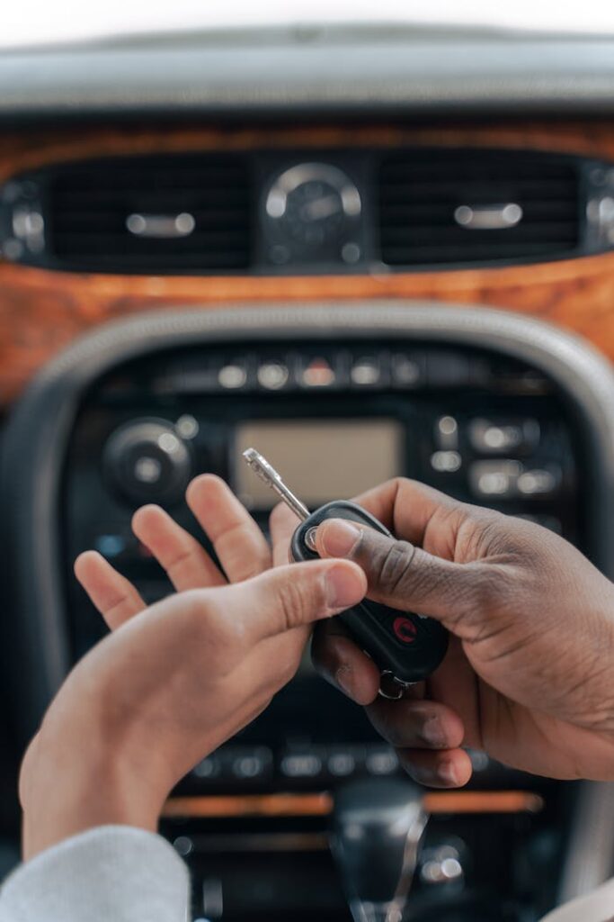 pexels-photo-9518240 Two people exchanging car keys inside a luxury car, emphasizing guidance and learning.